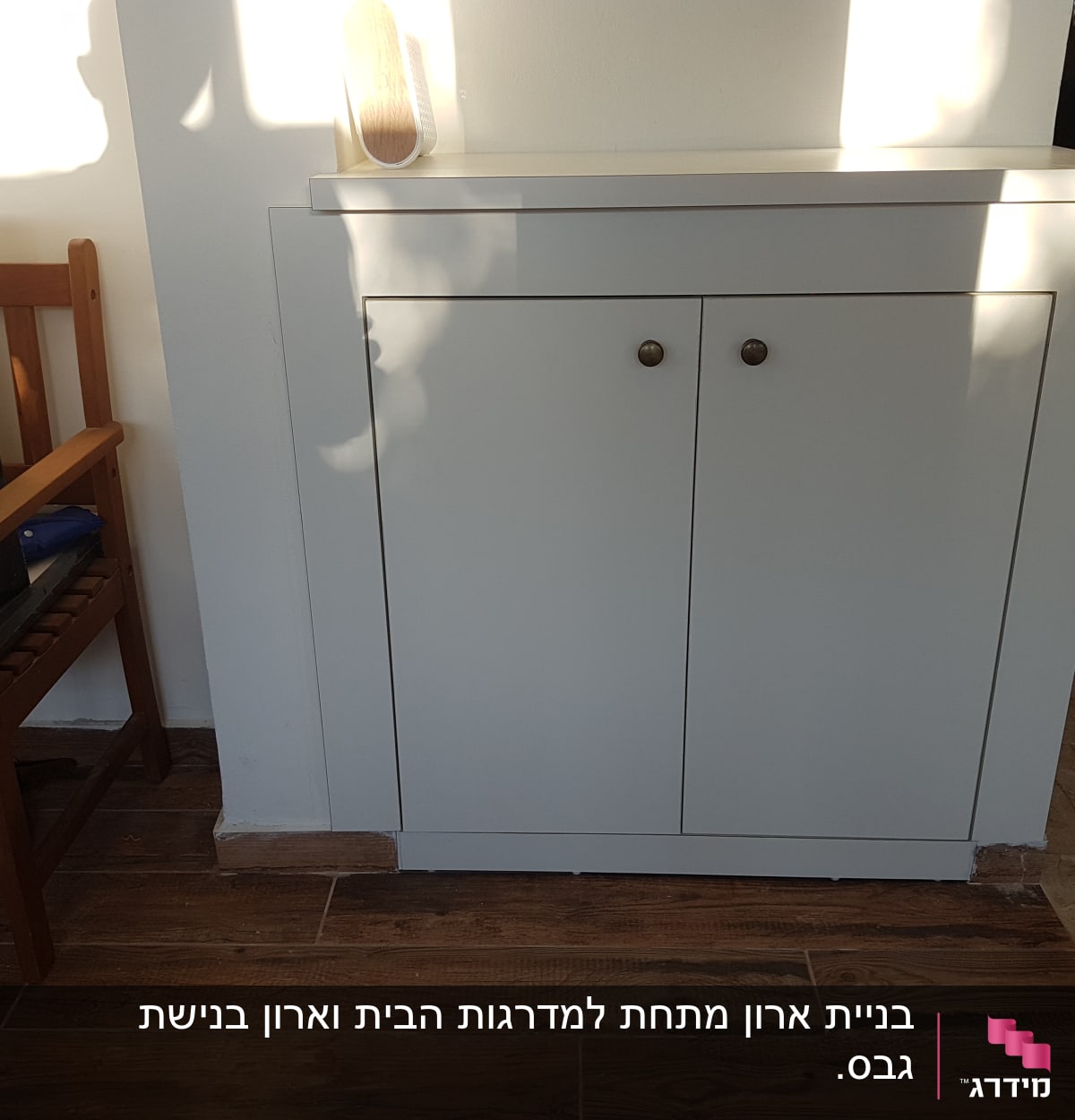 ארון עץ לבן עם שתי דלתות וידיות עגולות